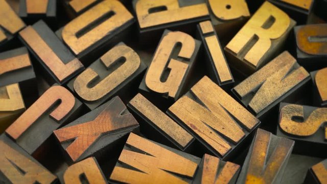 Vintage grunge letterpress wood type printing blocks rotating on a turntable (inverted image)