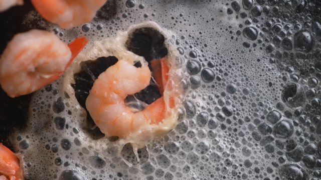 Cooking shrimp with butter on heated fry pan. Overhead shot. Shot with high speed camera, phantom flex 4K. Slow Motion.