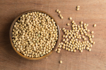 Soybeans in wooden bowl on wooden background.
