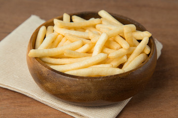 French fries or potato fry in wooden bowl on wooden background.