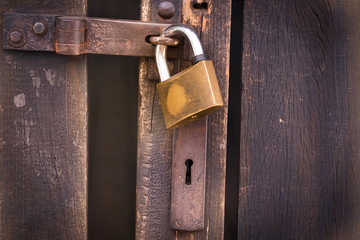 Close up view of a padlock and old wooden door