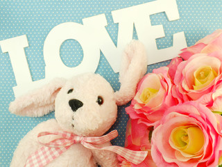 love word with roses flowers bouquet and cute doll valentine's day concept background
