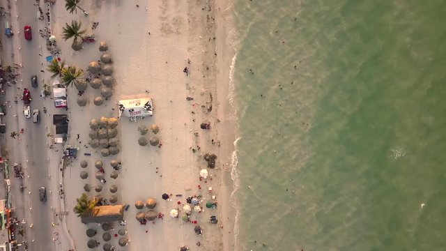 Toma aerea con drone en movimiento sobre playa con gente turista