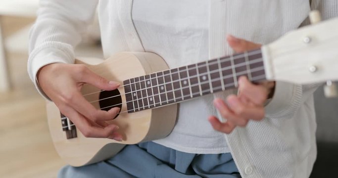 Woman play a music on ukulele