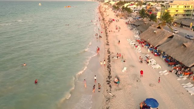 Toma aerea con drone en movimiento sobre playa con gente turista