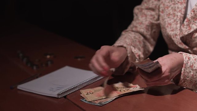 A Brazilian lady counts her money to be able to pay the bills of the month