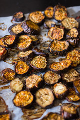 Roasted, grilled eggplants round slices with oregano herbs, spices baked on parchment paper in oven. Vegan vegetarian healthy lunch or dietary dinner.