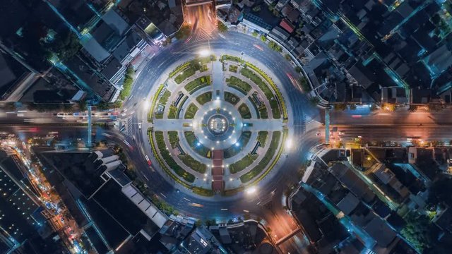 timelapse of night city traffic on 4-way stop street intersection circle roundabout in bangkok, thailand. 4K UHD horizontal aerial view.