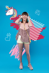 Dreamy girl. Happy teenage girl smiling and looking excited while listening to music in her big headphones and dreaming about having a real unicorn