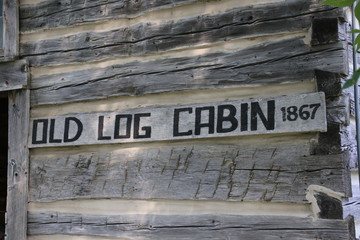 An "old log cabin" sign for a home from the 1800s