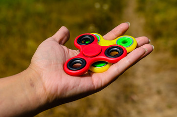 Red and yellow fidget spinners in female hand