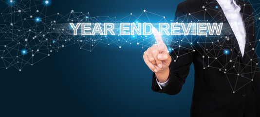 Year End Review concept with Hand of business pressing a button Year End Review