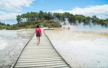 Schilderijen op glas Asian tourist walking on the boardwalk across the Artist's Palette to Champagne pool an iconic tourist attraction of Wai-O-Tapu the geothermal wonderland in Rotorua, New Zealand.   © boyloso