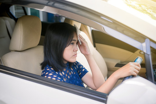 Asian woman having hot beacuse a heat wave in her car,Broken air conditioner