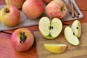 Naklejka na ściany i meble Ripe apples on a table, chopped apple, autumn harvest concept.
