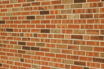 Angle view of a vintage brown multi-tone brick wall background with Flemish stretcher bond brickwork pattern