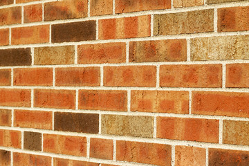 Angle view of a vintage brown multi-tone brick wall background with Flemish stretcher bond brickwork pattern