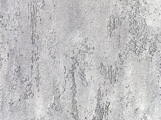 Old gray wall covered with uneven plaster. Texture of vintage shabby silver stone surface, closeup.