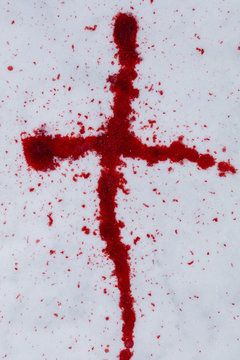 A cross made of red blood on a white snow in Finland.