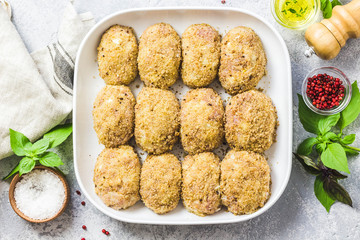 Healthy oven baked chicken rissoles on baking dish, ready for cooking. Top view, space for text.