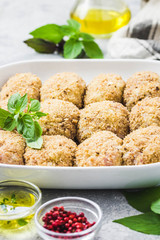 Healthy oven baked chicken rissoles on baking dish, ready for cooking. Selective focus, space for text.