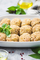 Healthy oven baked chicken rissoles on baking dish, ready for cooking. Selective focus, space for text.