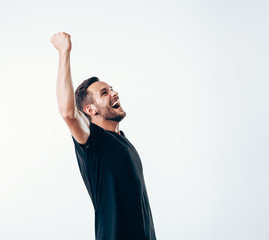 Handsome man with arms up celebrating success