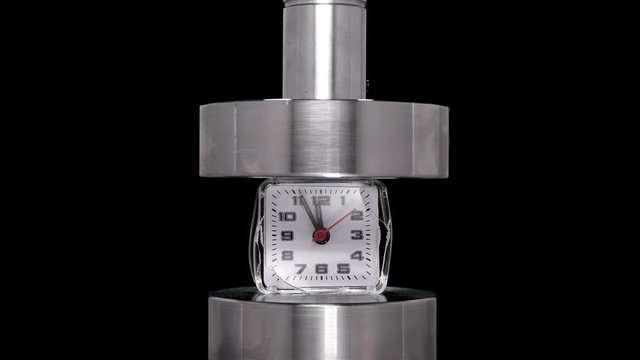 crash test alarm clock, hours under hydraulic press, close-up