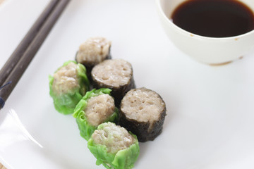 Seaweed algae with Pork Dim sum on white plate.
