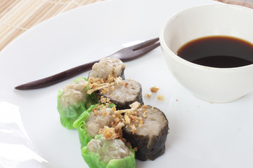 Seaweed algae with Pork Dim sum on white plate.