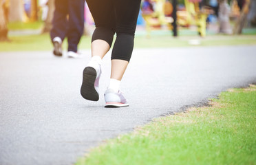 Running shoes and strong athletic legs jogging in health public park