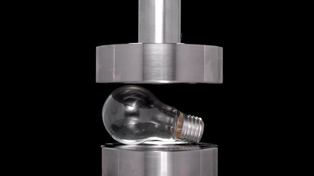 crash test light bulb under hydraulic press, close-up