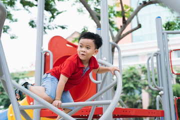 happy little boy climbing on children playground