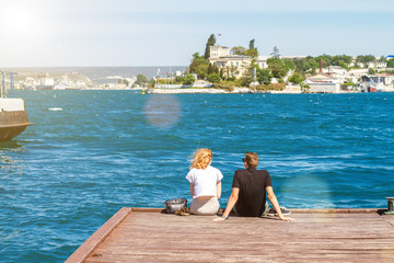 couple sitting on the pier on a Sunny day