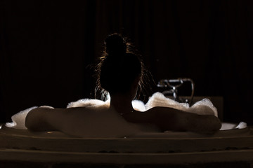 back of view woman take a bath in bathtub,Low key - obrazy, fototapety, plakaty