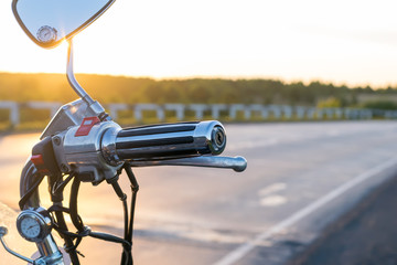 view of handlebar grips of the motorcycle on the country road background closeup