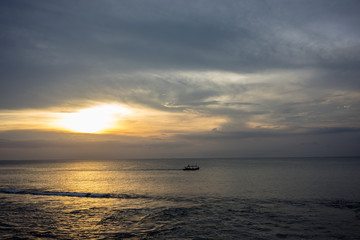 Fototapeta premium fisherboat in horizon on sunset at sea in Bali, Indonesia