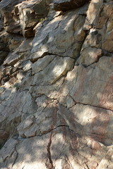 Granite rocks in the sun. Texture of granite stone. Background of natural material. Rocky rocks of ancient times. Minimalism