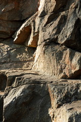 Granite rocks in the sun. Texture of granite stone. Background of natural material. Rocky rocks of ancient times. Minimalism