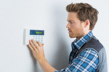 Man entering code on alarm keypad