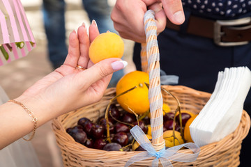 Basket with fruit and a woman's hand taking them