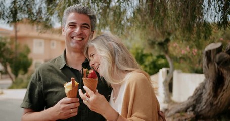 Happy mature couple eating ice cream on romantic date - Powered by Adobe