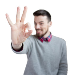Young pretty smiling man  gesturing OK sign isolated on white background