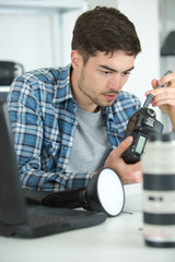 young man fixing camera