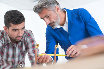 plumber and apprentice fitting central heating