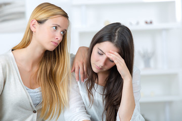 worried teenage girl and her friend supporting her