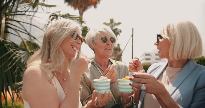Fashionable senior women eating ice cream in the city together