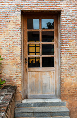 Old wooden door of brick house.