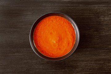 Soup gazpacho, Italian cuisine. Plate with soup in a black plate on a black background. Top Vieux. Copyspace.