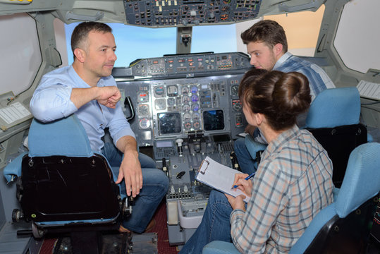 Three people in aircraft cockpit